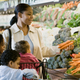 Mother and three kids shopping for produce